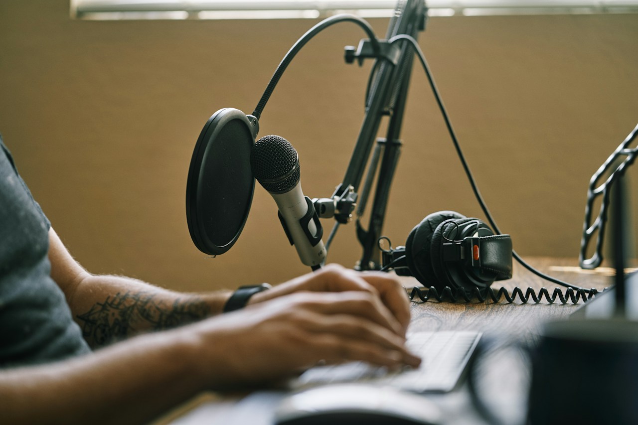 A creator recording a podcast episode at a home studio desk.