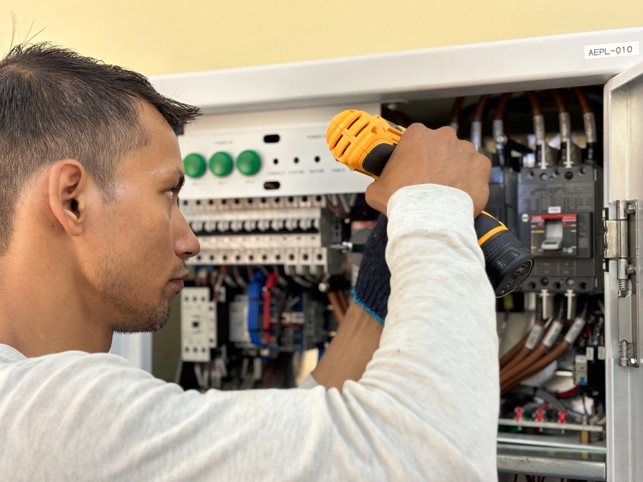 An electrician working on a residential electrical panel.